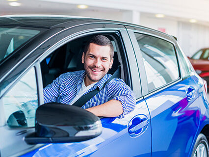 Man in car at dealership