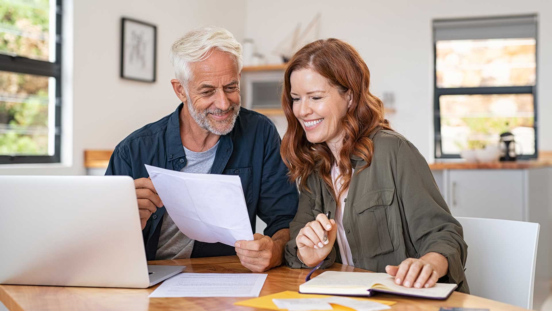 two happy seniors using laptop